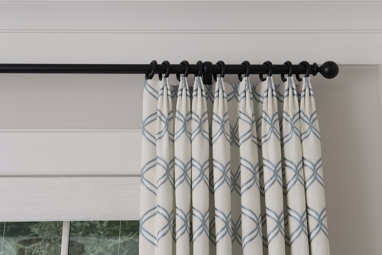 Patterned drapery panels on a black rod